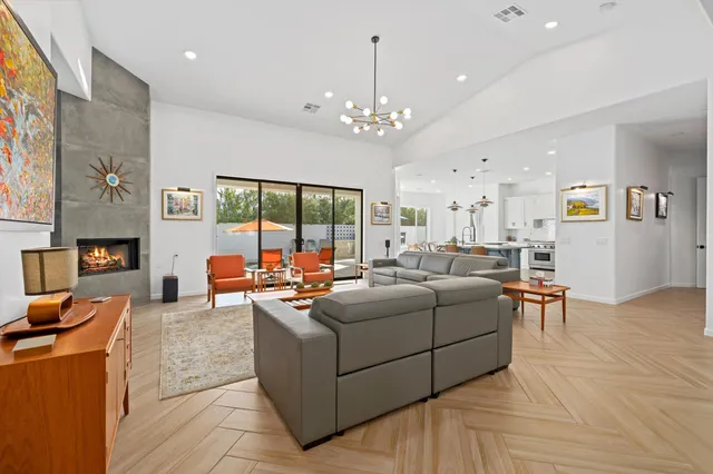 a living room with furniture a chandelier and a dining table