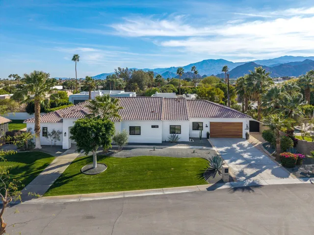 a bathroom with a granite countertop toilet sink vanity and mirror