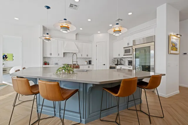 a kitchen with a dining table chairs and sink