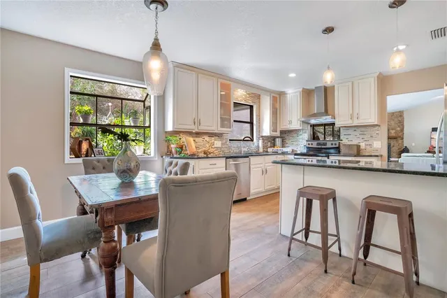 a kitchen with stainless steel appliances granite countertop a stove a sink a microwave a refrigerator and cabinets