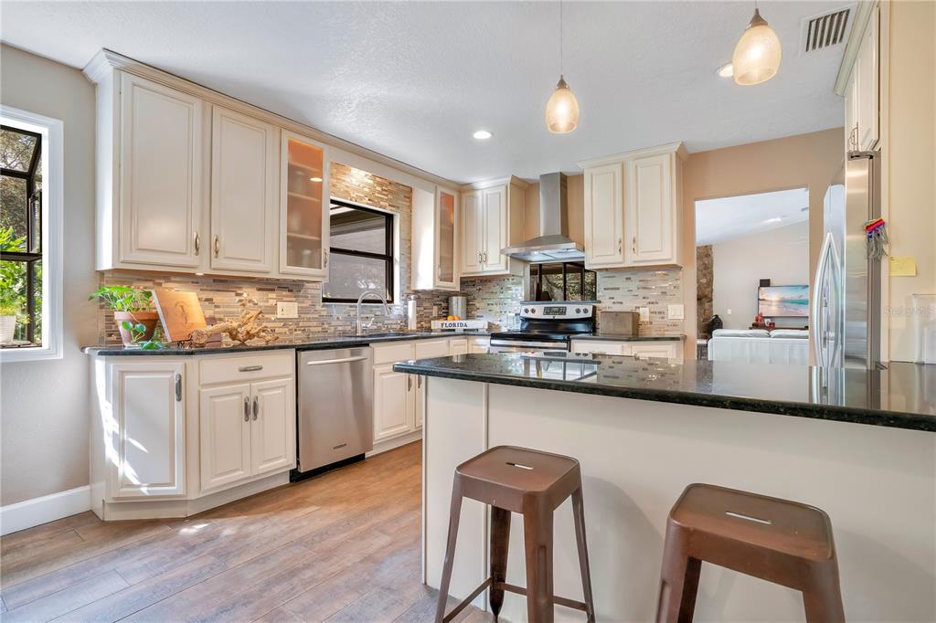 9488 Shortleaf Court Apopka, FL 32703 - Photo 25 of 60 a kitchen with stainless steel appliances granite countertop a stove a sink a microwave a refrigerator and cabinets