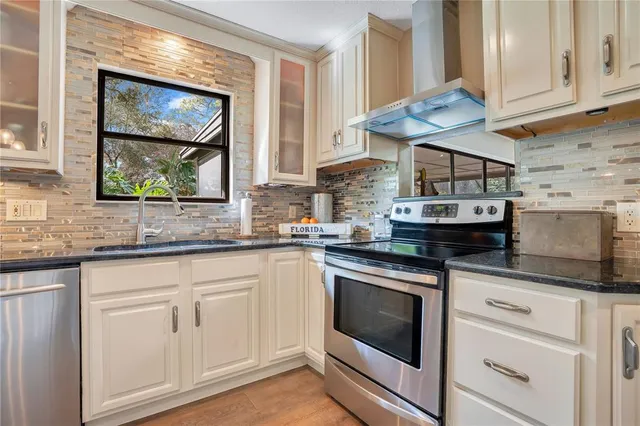 a kitchen with stainless steel appliances granite countertop a stove a sink and a microwave