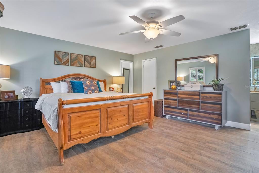 9488 Shortleaf Court Apopka, FL 32703 - Photo 33 of 60 a bedroom with a large bed and a chandelier