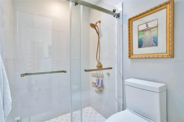 a bathroom with a double vanity sink toilet mirror and shower