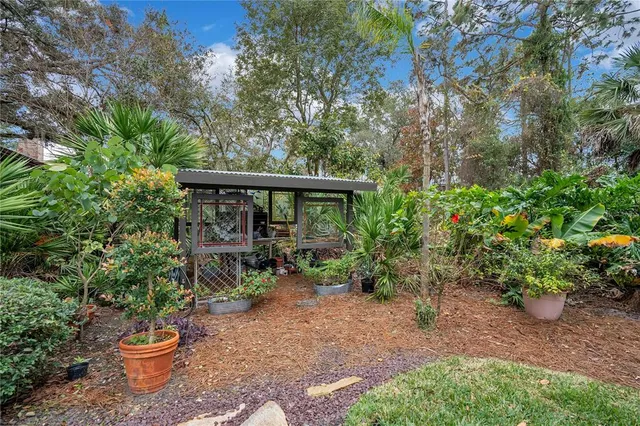 a yellow house with flower garden in front of it