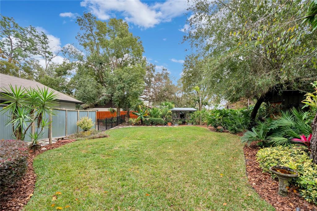 9488 Shortleaf Court Apopka, FL 32703 - Photo 57 of 60 a yellow house with flower garden in front of it