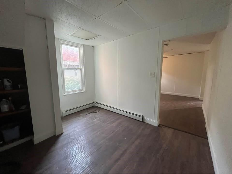 1136 Brownsville Road Pittsburgh, PA 15210 - Photo 18 of 28 an empty room with wooden floor and windows