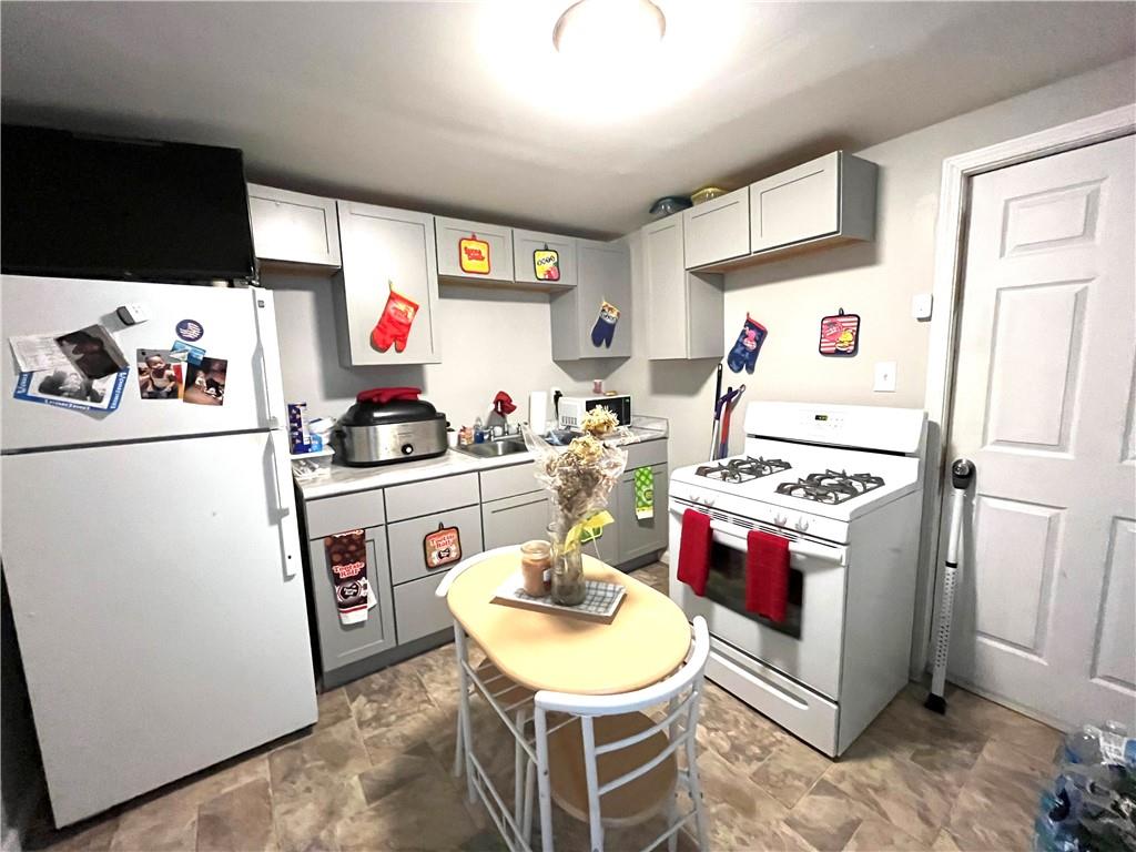 1136 Brownsville Road Pittsburgh, PA 15210 - Photo 26 of 28 a kitchen with a refrigerator and a stove top oven
