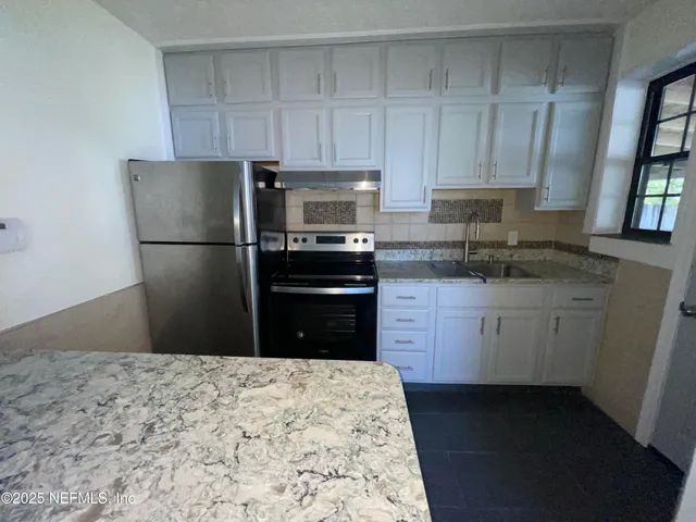 a kitchen with a refrigerator stove and sink