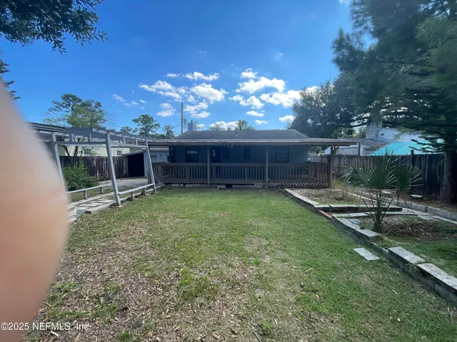 a view of a backyard with couches plants and large tree