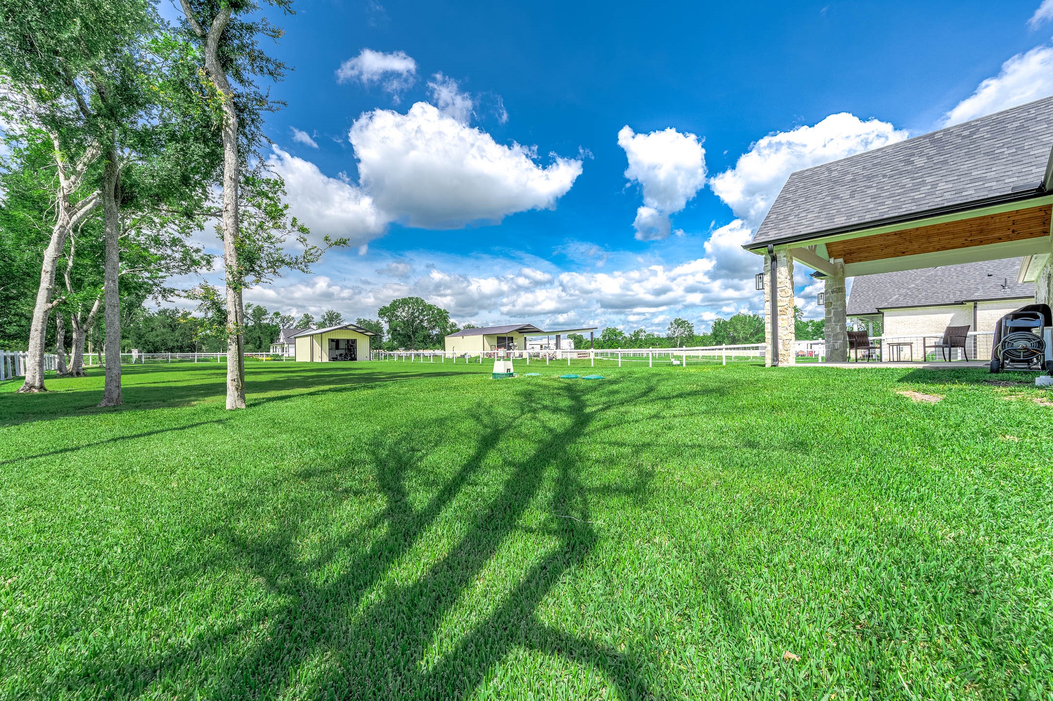 8032 Short Road Needville, TX 77461 - Photo 30 of 50 The property offers an expansive backyard with plenty of open green space, mature trees, and room to enjoy outdoor living. Additional structures provide excellent flexibility for storage, workspace, hobbies, or recreational use while enhancing the functionality of the property.