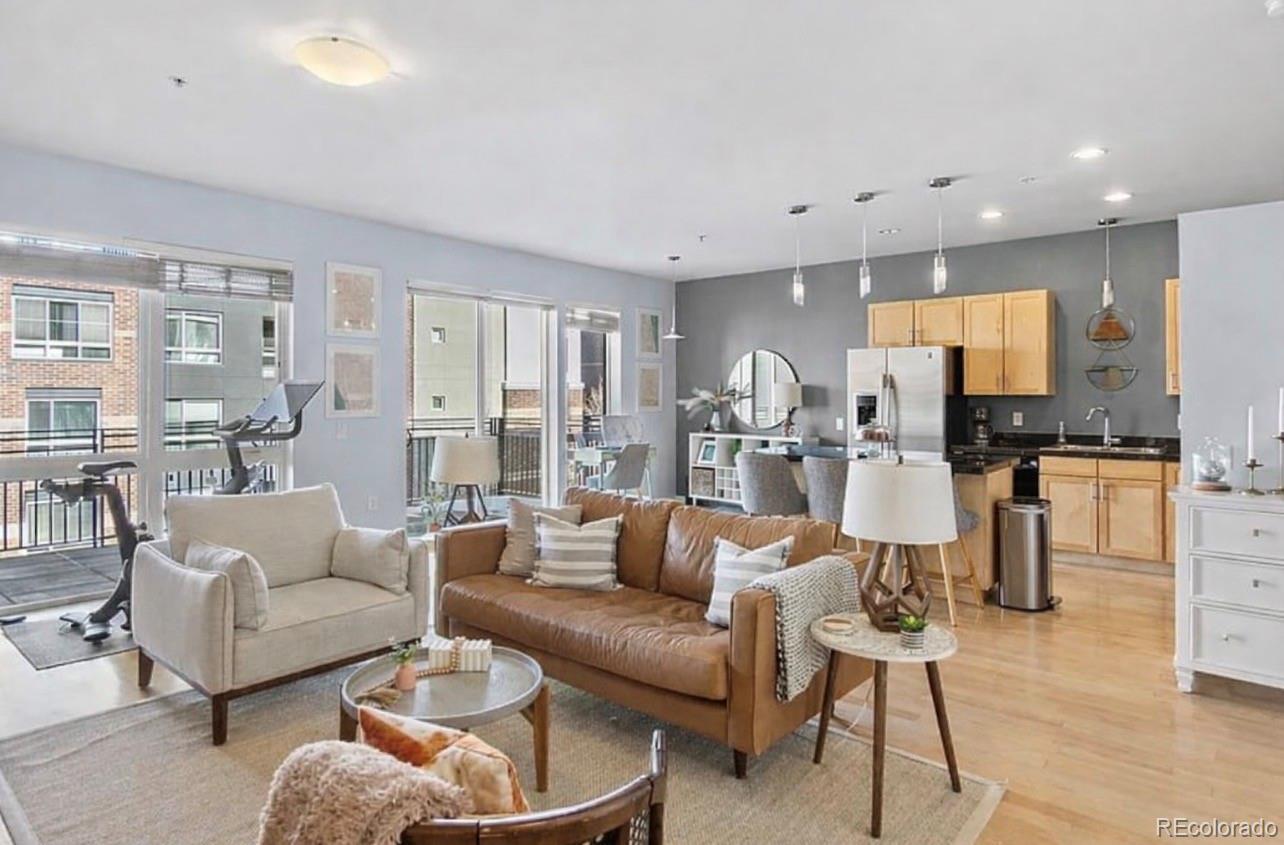 a living room with furniture kitchen view and a large window