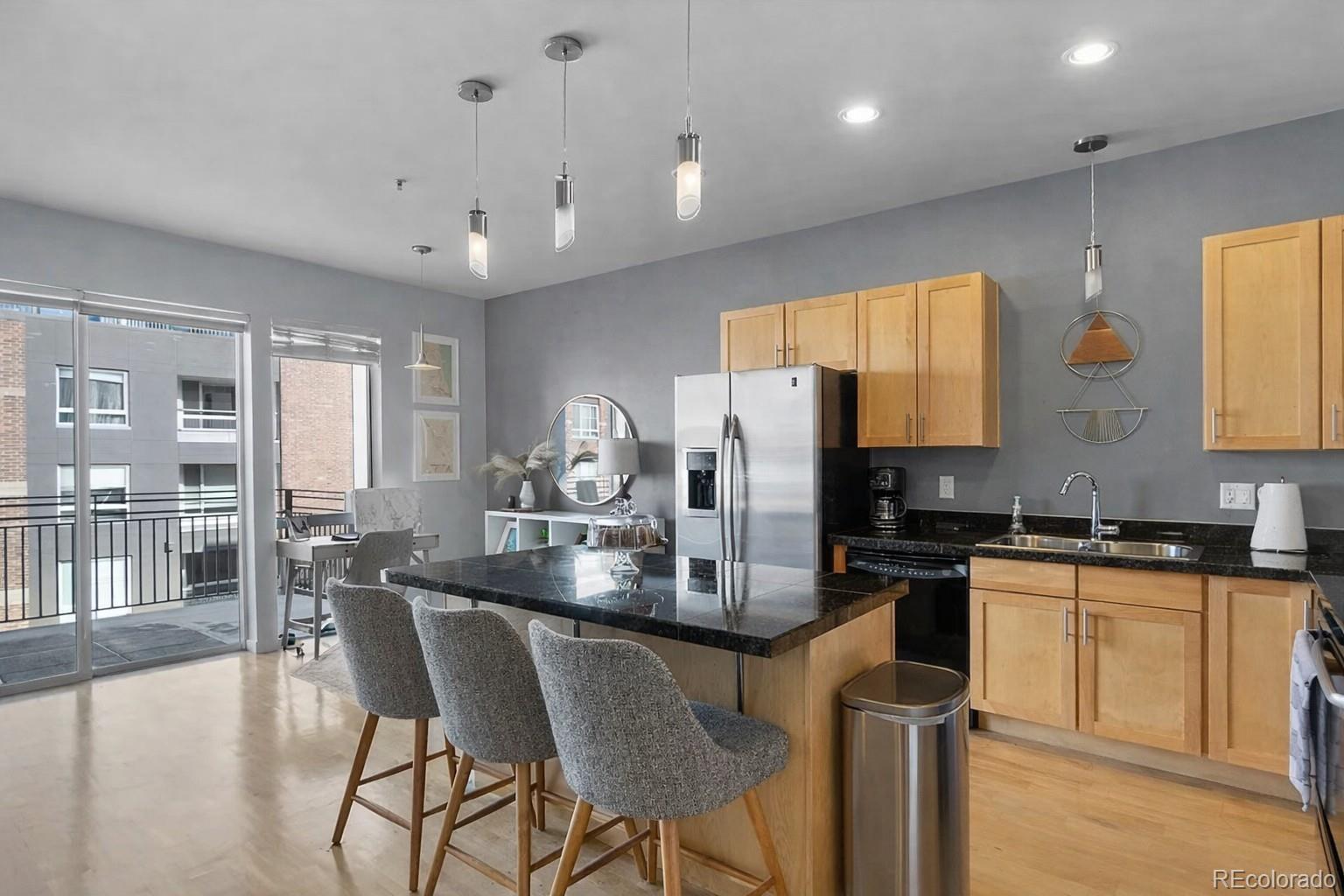 1438 Little Raven Street, Unit 310 Denver, CO 80202 - Photo 9 of 24 a kitchen with kitchen island granite countertop a sink and counter space