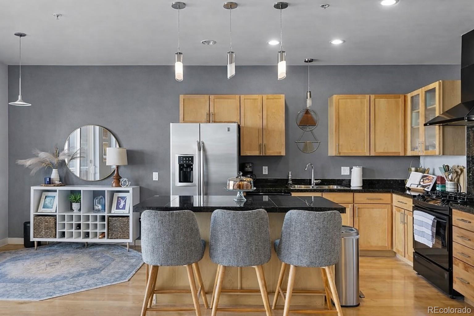1438 Little Raven Street, Unit 310 Denver, CO 80202 - Photo 10 of 24 a kitchen with stainless steel appliances granite countertop a sink a stove a refrigerator cabinets and a dining table