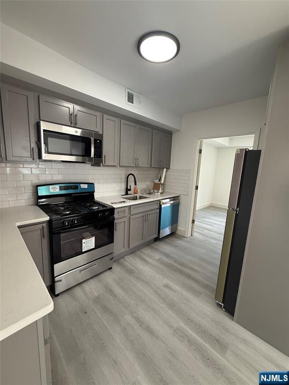 146 Maple Street, Unit 2 Kearny, NJ 07032 - Photo 11 of 12 a kitchen with stainless steel appliances a sink stove and refrigerator