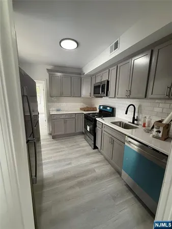a kitchen with stainless steel appliances a sink stove and refrigerator