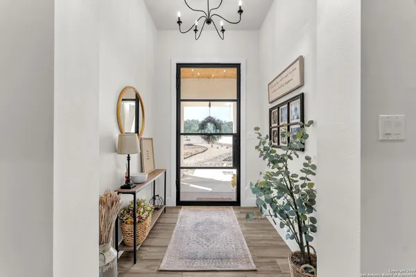 a kitchen with stainless steel appliances granite countertop a sink a stove a dining table and chairs with wooden floor