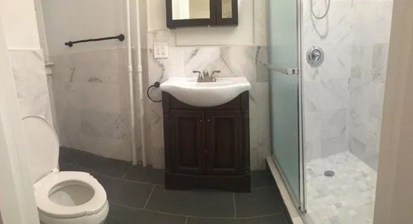 a bathroom with a sink a toilet and shower
