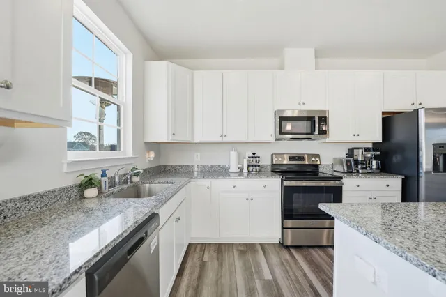 a kitchen with a sink stove top oven and refrigerator