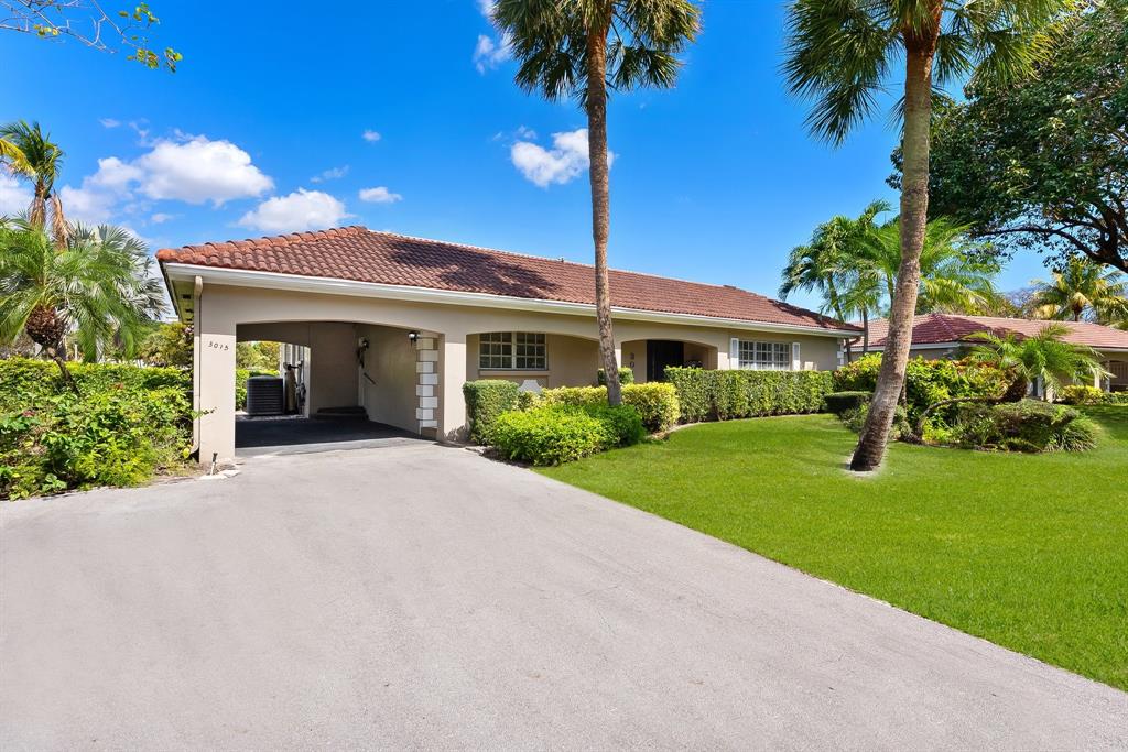 a front view of a house with a yard and potted plants