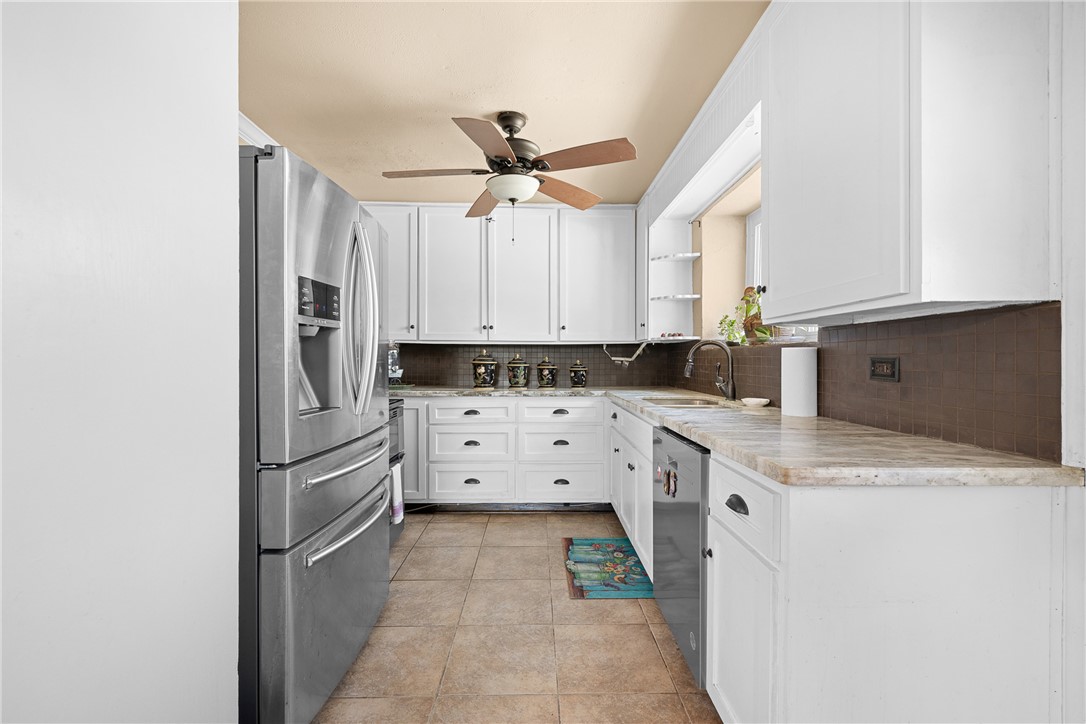 10415 McKnight Road Brenham, TX 77833 - Photo 11 of 23 a kitchen with white cabinets and stainless steel appliances