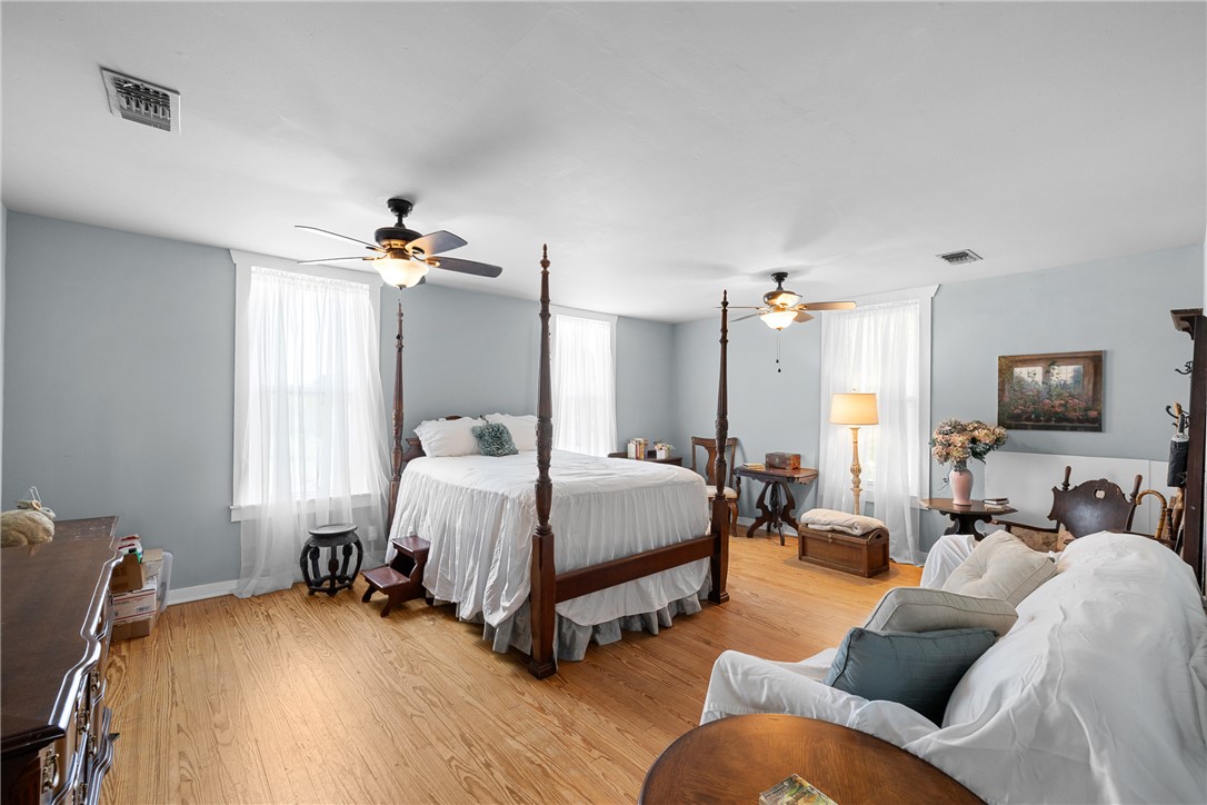 10415 McKnight Road Brenham, TX 77833 - Photo 17 of 23 a spacious bedroom with a bed and wooden floor