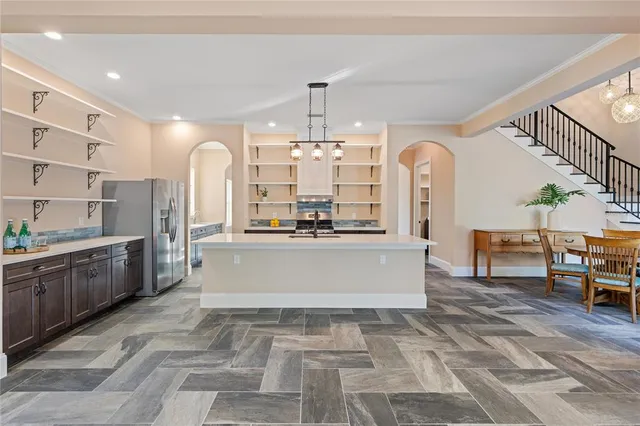 a large kitchen with kitchen island a large counter space a sink appliances and cabinets