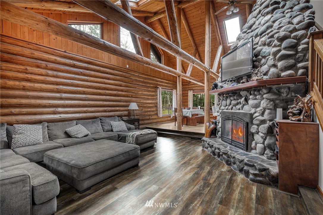 27253 Webster Road East Graham, WA 98338 - Photo 12 of 32 a view of a patio with couches and a fireplace with wooden floor