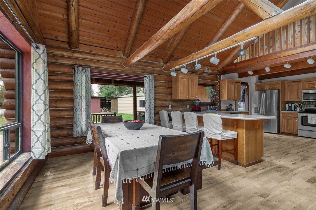 27253 Webster Road East Graham, WA 98338 - Photo 18 of 32 a dining table with chairs and kitchen view