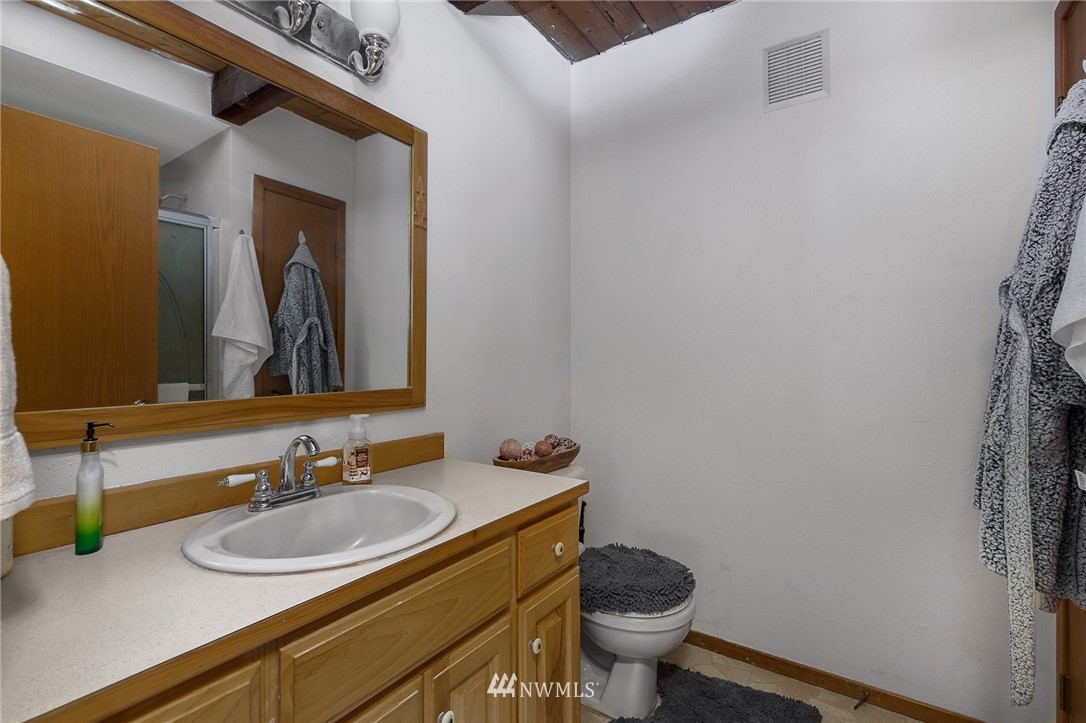27253 Webster Road East Graham, WA 98338 - Photo 22 of 32 a bathroom with a granite countertop sink and a mirror