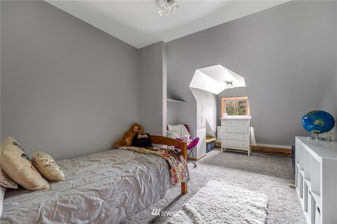 27253 Webster Road East Graham, WA 98338 - Photo 26 of 32 a bedroom with a bed and a chandelier