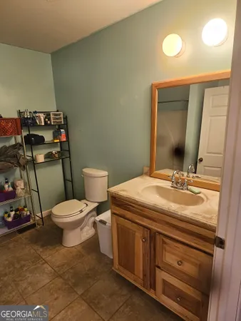 a bathroom with a toilet sink and mirror