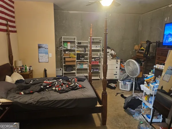 a bedroom with a bed a table and a chandelier