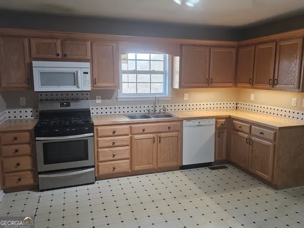 a kitchen with a stove a sink and a microwave