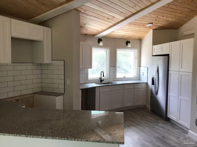 a kitchen with stainless steel appliances granite countertop a refrigerator and a sink