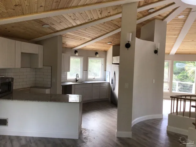 a view of a kitchen with a sink and wooden floor