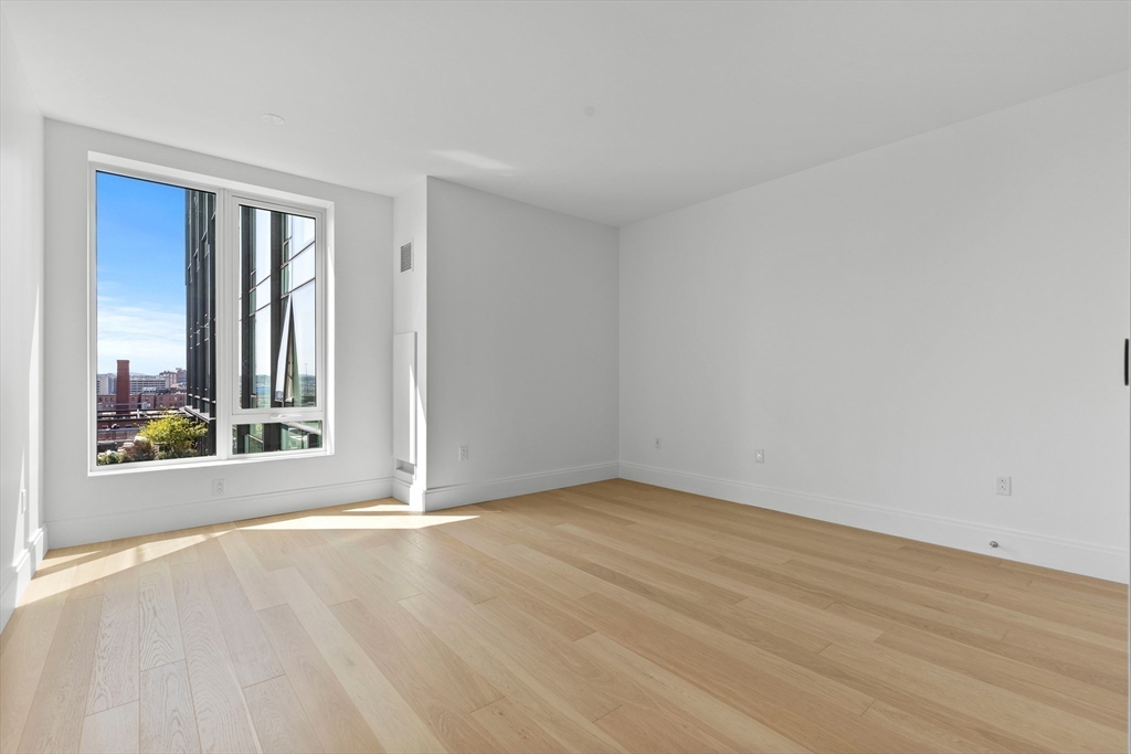380 Harrison Avenue, Unit 1005 Boston, MA 02118 - Photo 6 of 14 a view of an empty room with wooden floor and a window