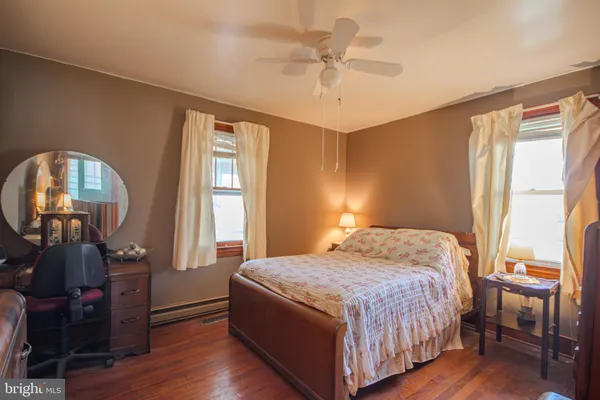 a bedroom with a bed a window and wooden floor