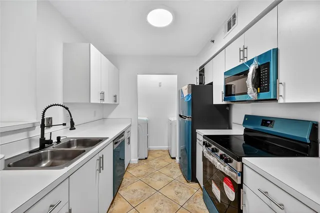 a kitchen with stainless steel appliances a sink a stove and a microwave