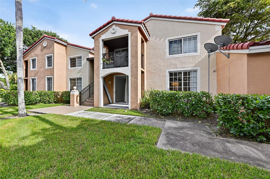 2011 Renaissance Boulevard, Unit 101 Miramar, FL 33025 - Photo 2 of 32 a front view of a house with a yard and garage