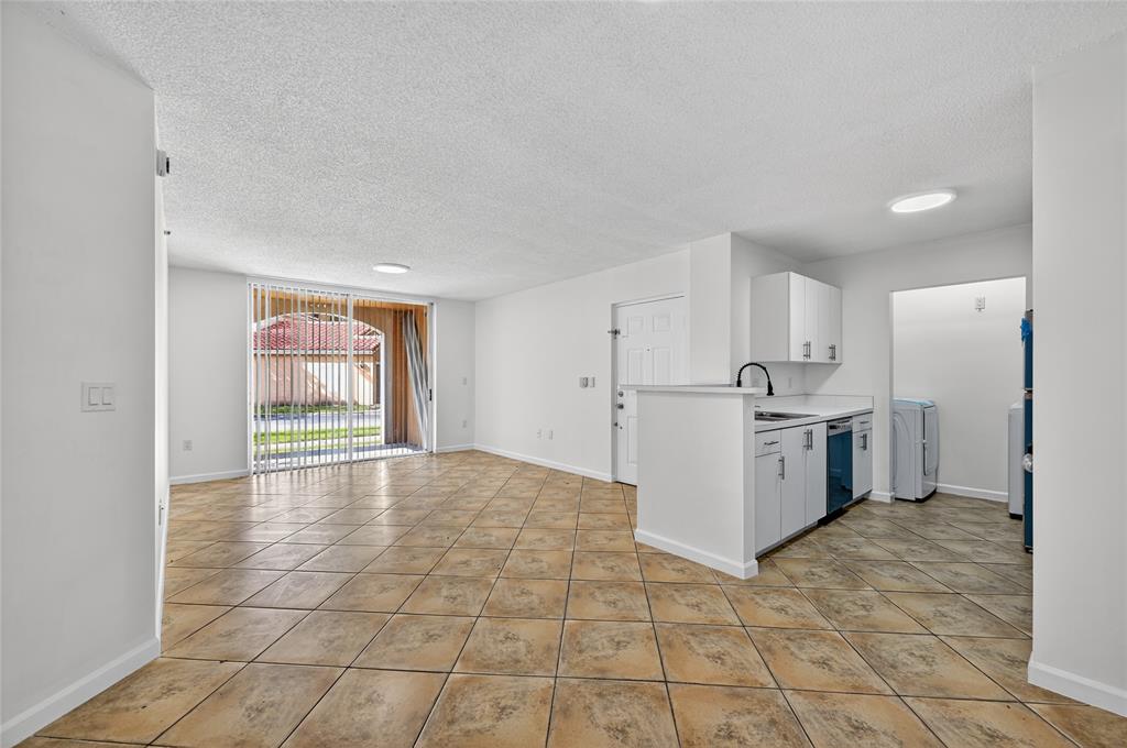 2011 Renaissance Boulevard, Unit 101 Miramar, FL 33025 - Photo 21 of 32 a view of a kitchen with refrigerator and white cabinets