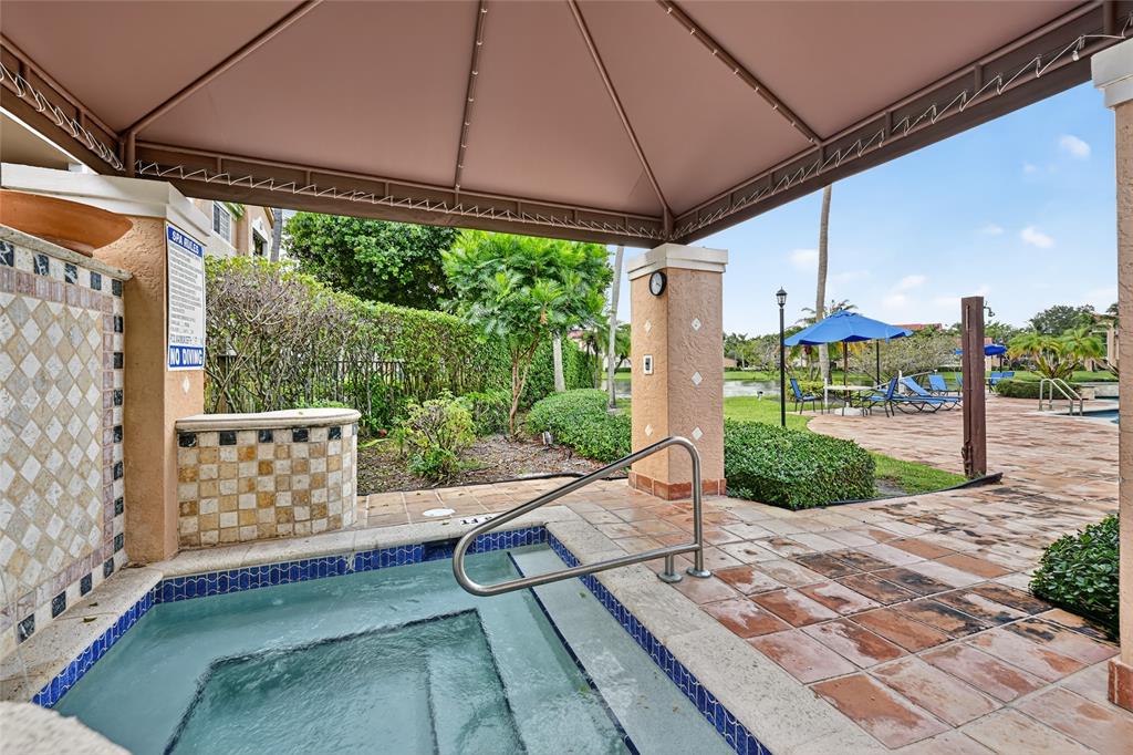 2011 Renaissance Boulevard, Unit 101 Miramar, FL 33025 - Photo 9 of 32 a view of a patio with table and chairs under an umbrella