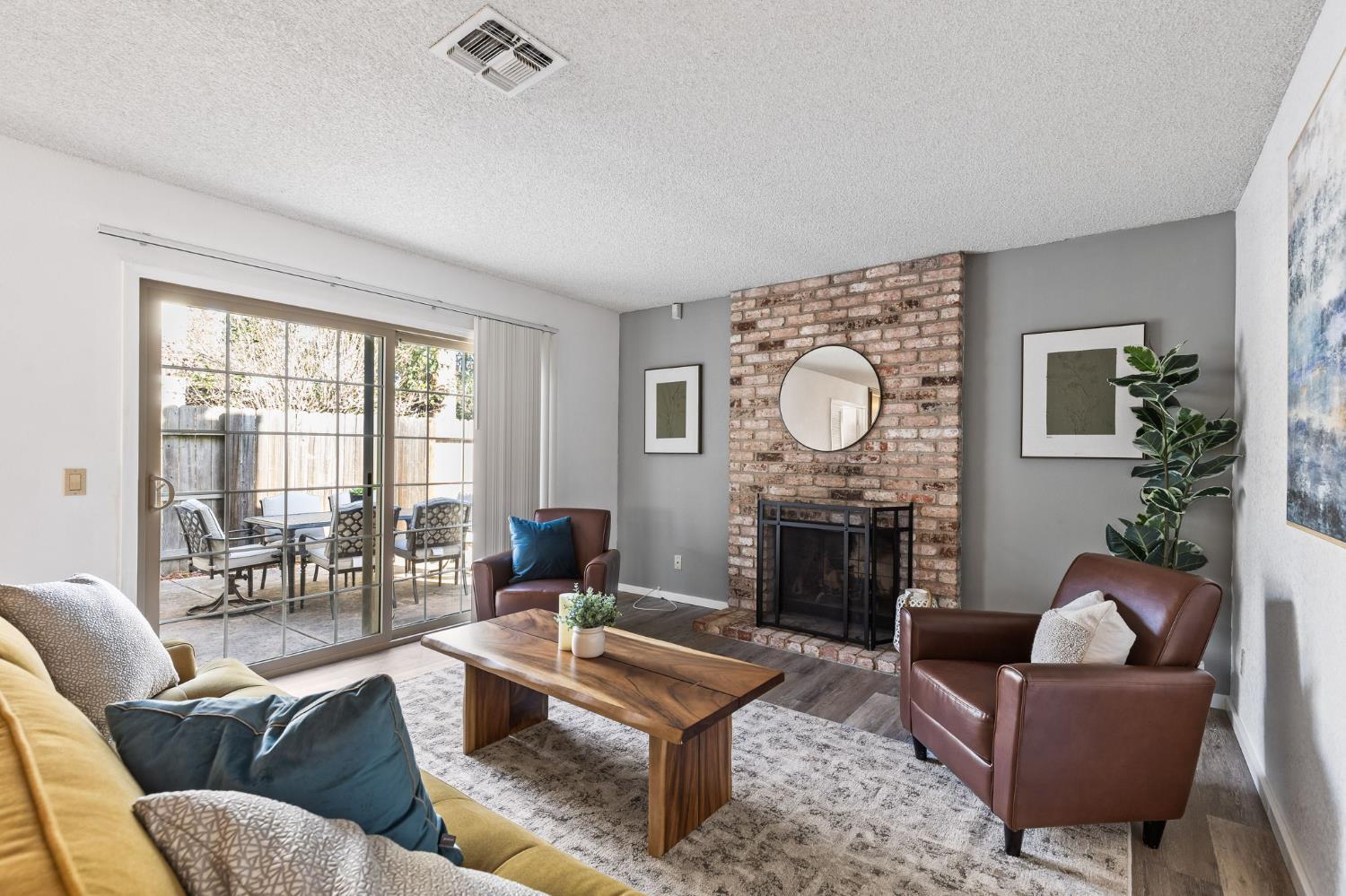 a living room with furniture a fireplace a rug and a large window