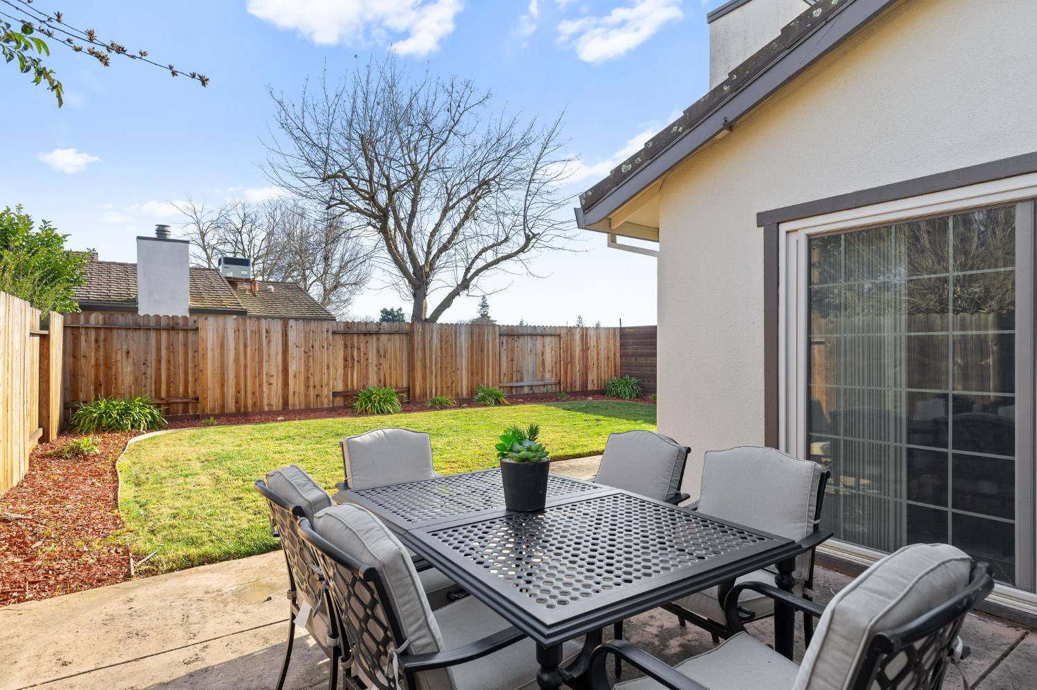 10938 Anza Way Rancho Cordova, CA 95670 - Photo 2 of 37 a view of a backyard with table and chairs and wooden fence