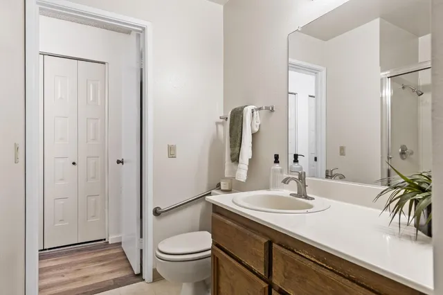 a bathroom with a sink a toilet and a large mirror