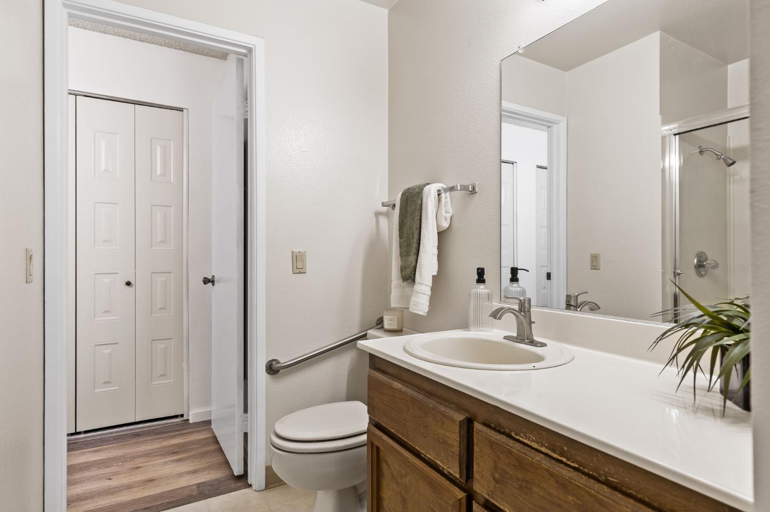 10938 Anza Way Rancho Cordova, CA 95670 - Photo 22 of 37 a bathroom with a sink a toilet and a large mirror