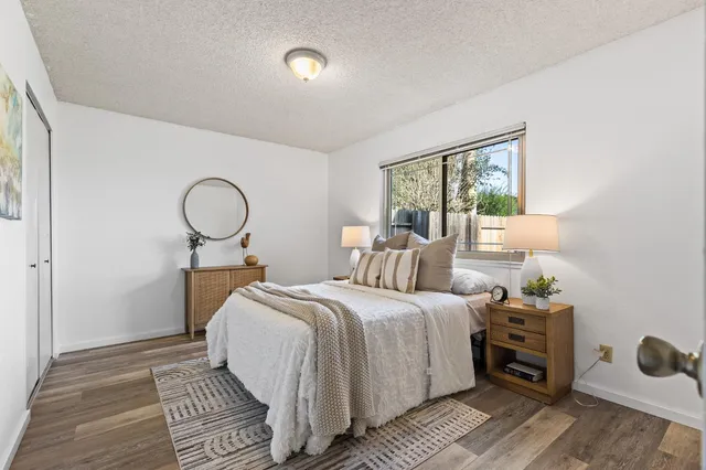a bedroom with a bed and wooden floor