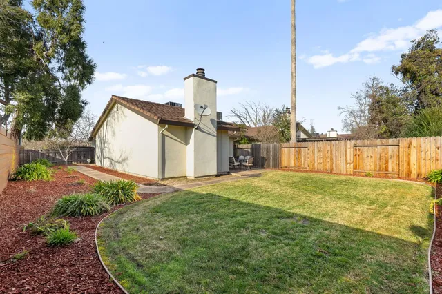 a view of a house with backyard and a tree