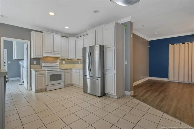 a kitchen with a refrigerator sink and cabinets