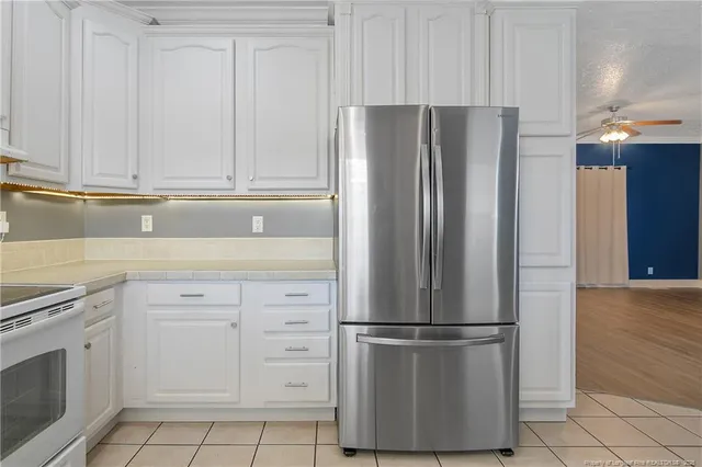 a white refrigerator freezer and a stove sitting inside of a kitchen